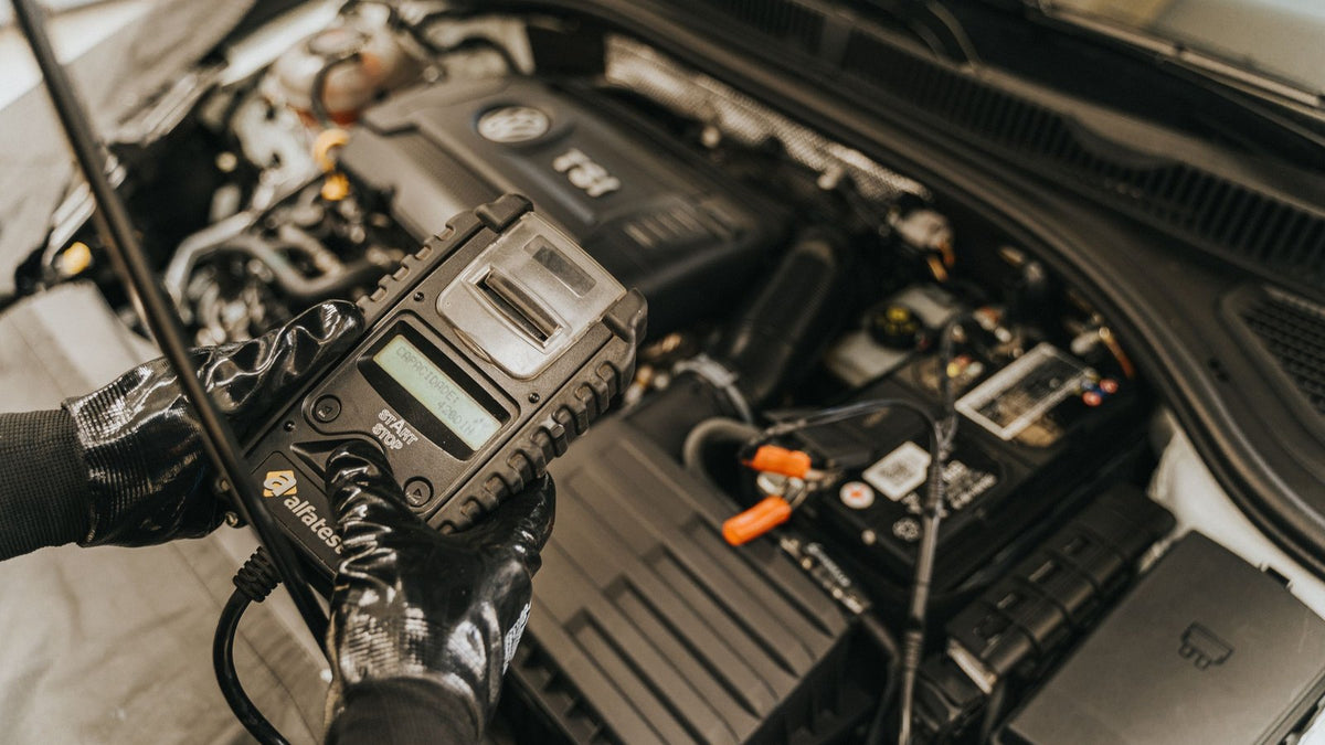 Mechanic using a diagnostic tool on a car engine
