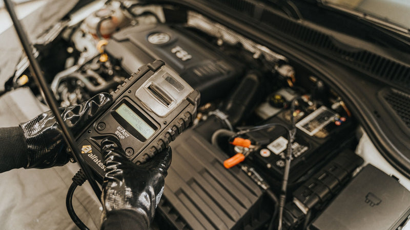 Mechanic using a diagnostic tool on a car engine