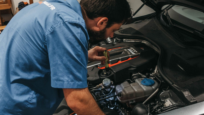 Mechanic checking a car engine under an open bonnet